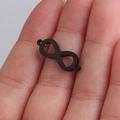 Vue macro d'un connecteur symbole infini noir pour la création de bijoux sur un doigt - Noir