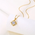 Detailed close-up of a golden clover pendant with crystal inlay and central zircon stone - Gold