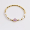 Bracciale a sfere dorate con perle e ciondolo a cuore viola in vista piana dall'alto - Viola