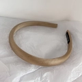 Detailed view of beige satin headband on white paper with a handmade label inside - Khaki