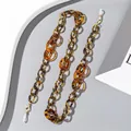 Detail einer Brillenkette aus Acryl mit bernsteinfarbener Schildpatt-Optik und Goldkarabiner - Bernstein/Schildpatt