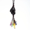 Detail of handmade raw black obsidian pendant with woven net and colorful chakra stones - Obsidian