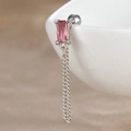 Détail d'un piercing hélix avec zircon rose et double chaîne argentée sur céramique - Rectangle Rose à Franges
