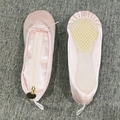 Detail view of pink satin ballet shoe pencil case with golden ring zipper and smooth texture - Pink