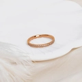 Close-up of a rose gold half eternity ring with micro-pave crystals on a white tray - US 5 / Rose Gold