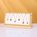 Bamboo necklace stand displaying six assorted gold plated pendants with colorful zircons - White / PU Leather
