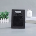 Detail shot of black paper gift bag featuring a transparent window and ribbon bow decoration - Small (16*12*6cm) / Black