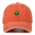 Dettaglio del ricamo alieno verde su un cappellino in cotone lavato color corallo - Arancione