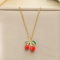 Detail of a cherry pendant necklace with gold chain and red enamel on a jewelry pad - Enamel Red Green Cherry Style (KN292078-Z)