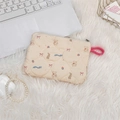 Detailed macro view of cream quilted cosmetic pouch featuring cute cartoon animal patterns - Blue Ribbon Bear