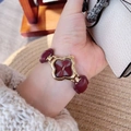 Women's watch with golden clover case and deep red leather strap worn on wrist - Four-Leaf Clover Leather Chain