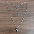 Silver-finish cross necklace with clear zircons on a rustic wooden background - Movable With Crown Cross Silver