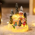 Beleuchtetes Weihnachtshaus mit Weihnachtsmann und schneebedeckten Tannenbäumen - Kirche Weihnachtsmann Landschaft