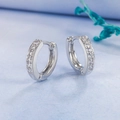 Sparkling silver hoop earrings with clear cubic zirconia stones on blue background - White Gold with White Zirconia