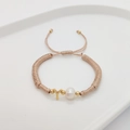 Detail of champagne woven bracelet featuring white pearl and golden letter Y charm - Letter Y