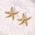 Boucles d'oreilles étoile de mer dorées avec texture martelée sur corail blanc - Doré