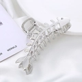 Pinza de metal plateado con diseño de espina de pescado sobre satén blanco - Plateado