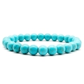 Close-up of 8mm natural turquoise beads bracelet with brown matrix on white background - Turquoise