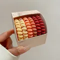 Nahaufnahme von fünf orangefarbenen Spiral-Haargummis in einer Marken-Verpackung - 16# Orange Serie
