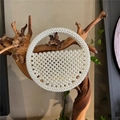 Dettaglio di una borsa di perle fatta a mano con design rotondo traforato su legno - Perla