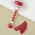 Detailed macro view of a red resin dual-head facial roller and heart-shaped gua sha tool - Resin Roller Big Red