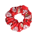 Close-up of red Christmas scrunchie with festive Santa Claus patterns and elastic fabric - Red