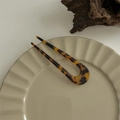Detail of tortoise shell resin U-shaped hair pin on a ceramic plate for vintage styling - Hair Fork