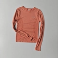 Detail of seamless yoga top featuring thumbholes and breathable texture in burnt orange - Pink