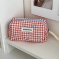 Detail of red checkered quilted makeup bag with blue bow pattern and blue zipper closure - Pencil Case / Red