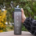Gradient grey sports water bottle with straw and time markers held in hand - Gradient Grey/Straw