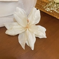 Eleganter weißer Stoff-Lilien-Haarclip mit rosa Staubblatt auf einem Holztisch - Entenschnabel Clip - Weiß