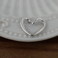 Pendentif cœur évidé en argent poli et acier inoxydable sur plateau blanc - Cœur / Acier