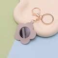 Light gray flower-shaped PU leather mirror keychain with gold hardware on display tray - Flower (Gray) / Gold Chain Clasp