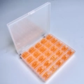 25 Orange Bobbins In A 25-compartment Box / Shuttle Core Storage Box