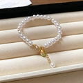 Minimalist pearl bracelet with gold beads and lobster clasp on beige velvet display - Simple Pearl Yellow Mango Pendant Style