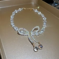 Macro detail of crystal bow necklace with teardrop pendants on a gold tray - 3# Necklace-Sweet Bow Waterdrop (HN2476)