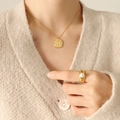 Collar con colgante de concha dorada y perla en modelo con ropa de punto beige - Dorado
