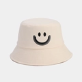 Close-up of cream cotton bucket hat featuring a black smiley face and premium stitching - Beige