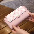 Pink floral faux leather long wallet for women featuring a golden metal buckle closure - Pink