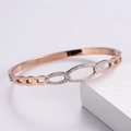 Detalle macro de la pulsera ovalada hueca en oro rosa con pavé de cristales brillantes - Cuff Bracelet / Oro rosa
