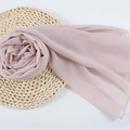 Light pink chiffon hijab scarf made of breathable fabric for women, folded on a woven mat - 96