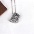 Macro shot of silver letter B pendant with a unique hammered texture on a bead chain - Letter B