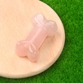 Polished pink crystal agate bone carving ornament displayed on a wooden base - Rose Quartz