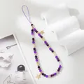 Detail shot of purple crystal beaded phone strap with gold star charms on a white background - Purple