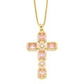 Macro view of a gold cross pendant with pink gemstones and white zircon halo detail - Pink