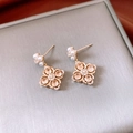 Detalle macro de elegantes pendientes de flor con circonitas brillantes y perlas finas - Pin de Plata S925 / Oro Café Claro