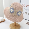 Pink and blue floral crochet straw sun hat with woven texture on a wooden stand - One Size / Pink