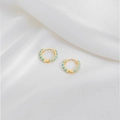 Detail view of gold hoop earrings with sky blue enamel dots on white silk fabric - Lake Blue