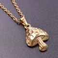 Close-up of polished gold mushroom pendant necklace on a dark textured background - Gold Necklace Set