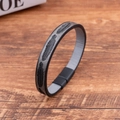 Detailed close-up of feather embossed black leather bracelet with magnetic metal clasp - Gray